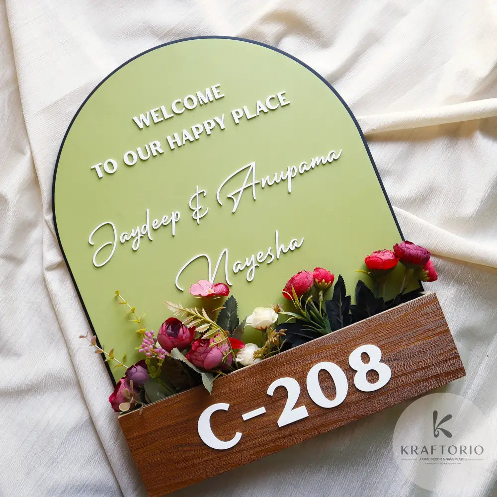 Personalized wooden nameplate with 3-layer floral pot design, artificial flowers, custom names and house number – handcrafted home entrance decor by Kraftorio